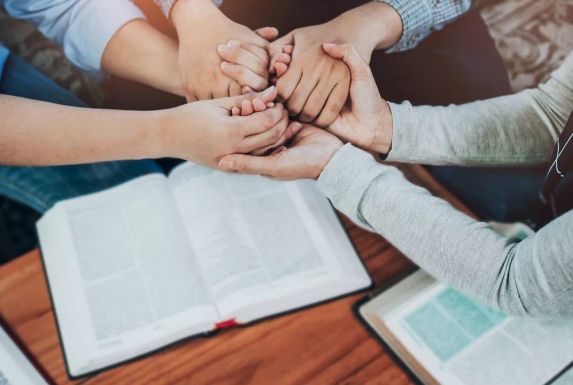 Group prayer with open books