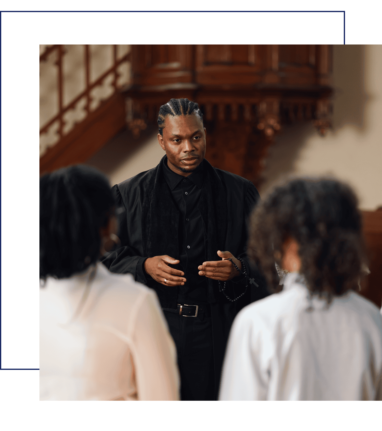 Man speaking to two people indoors.