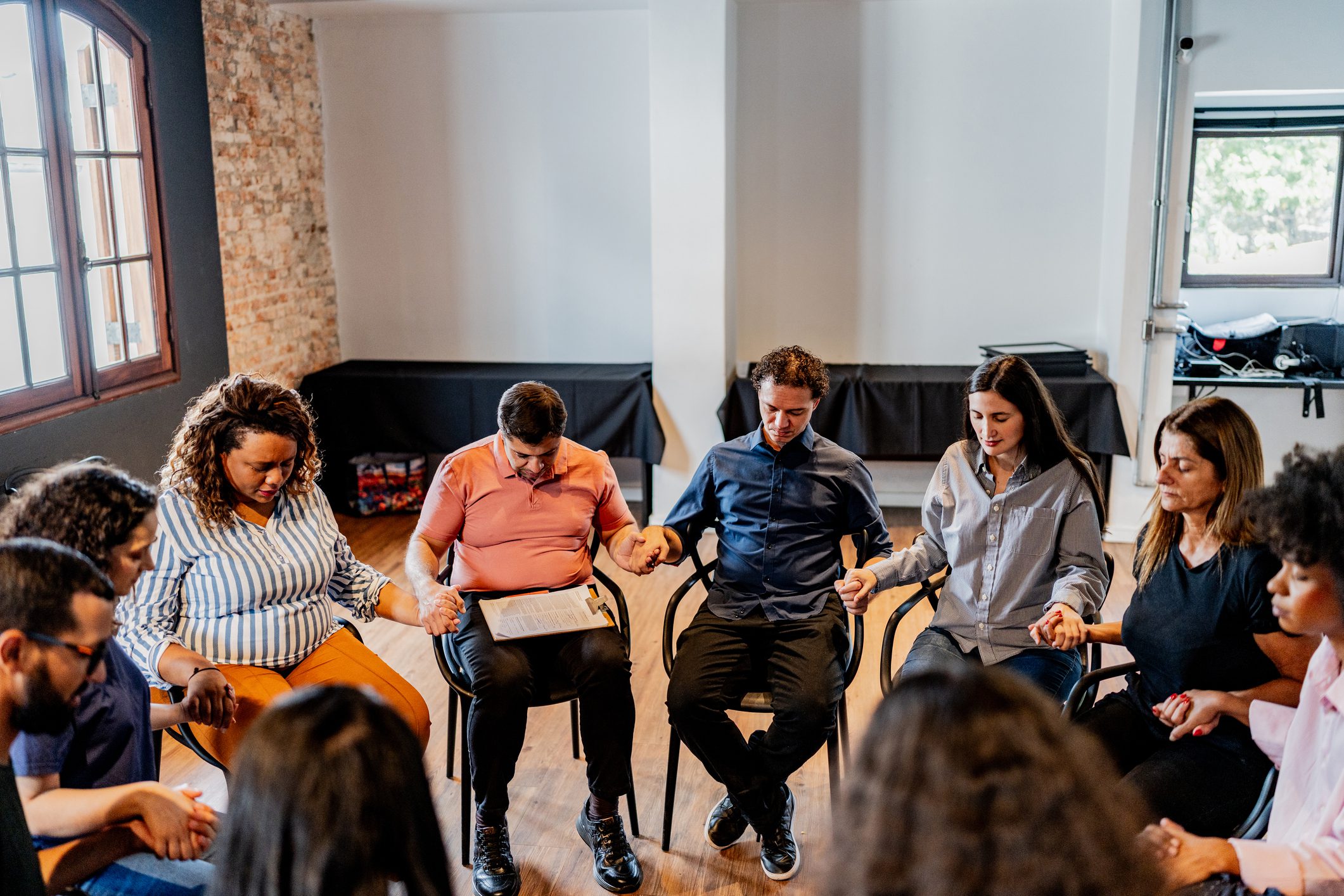 Group sitting in a circle holding hands.