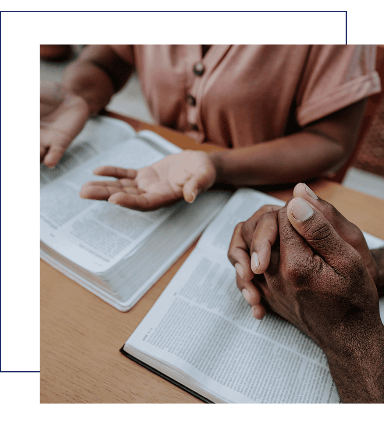 People praying with open books on table.