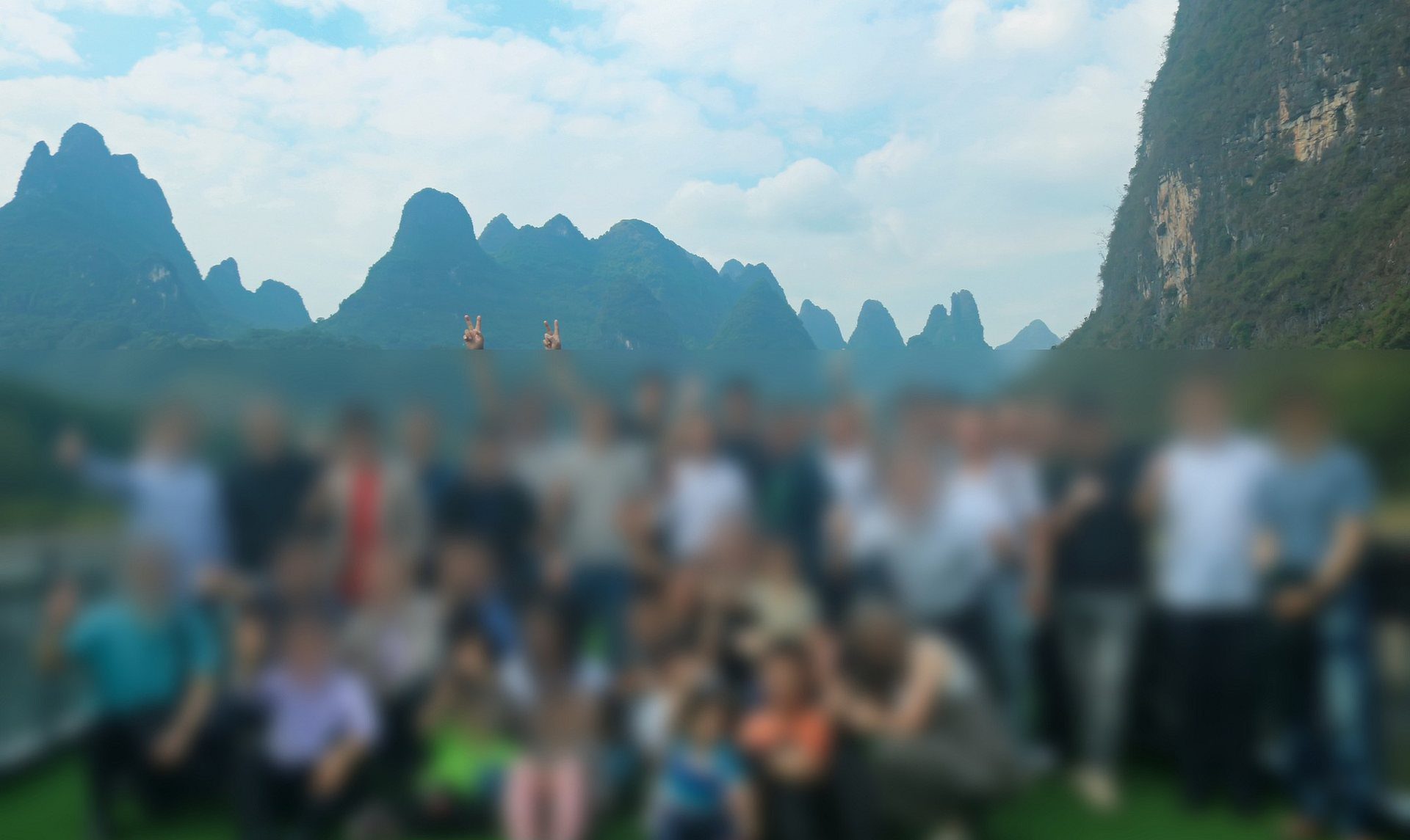 A ministry gathering against a mountain landscape, with faces blurred for privacy